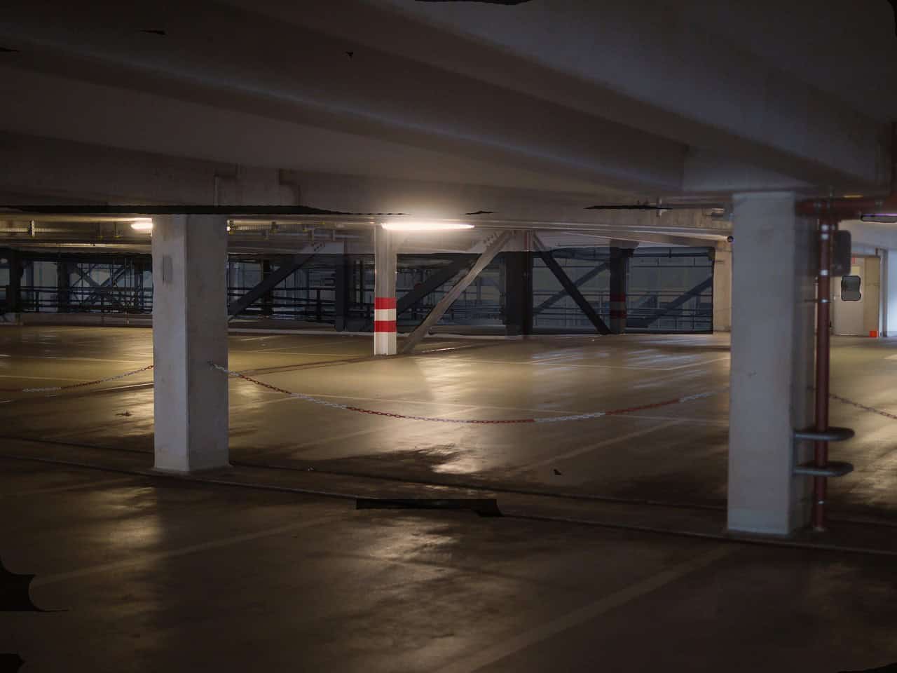 Leeres Parkhaus mit Beleuchtung und Säulen.
