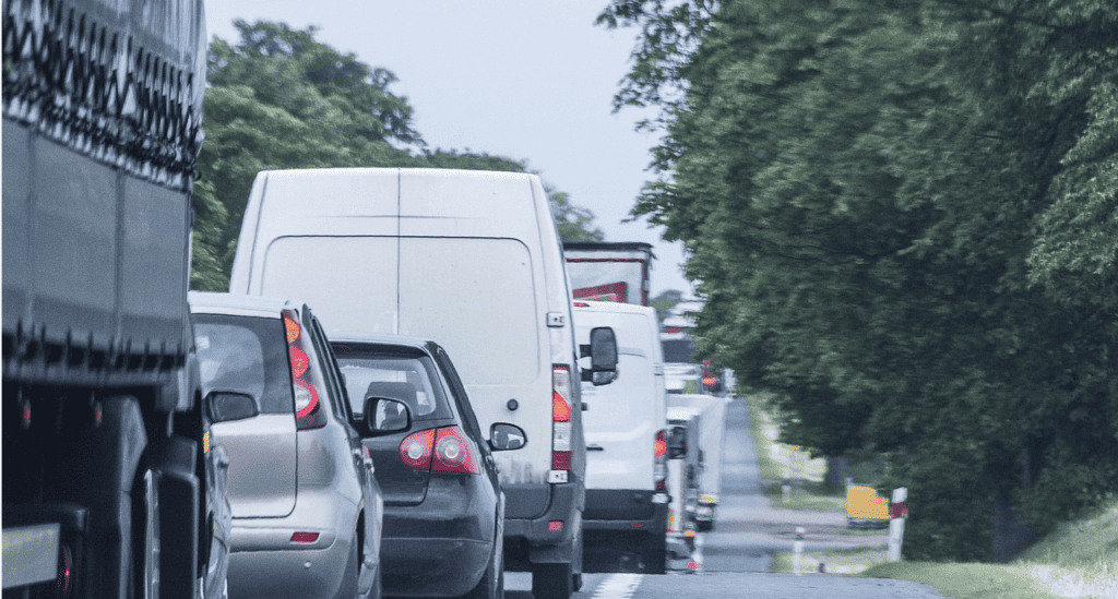 Fahrzeugkolonne vor einer Grundstückseinfahrt auf der rechten Seite