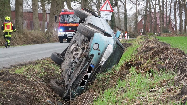 Auto im Graben nach Unfall, Feuerwehr vor Ort.