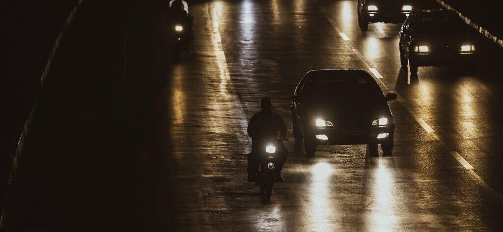 Nachtverkehr mit Fahrzeugen und Motorradfahrer  / mostafa_meraji
