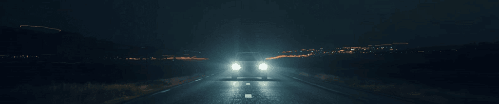 Auto mit Scheinwerfern auf dunkler Straße