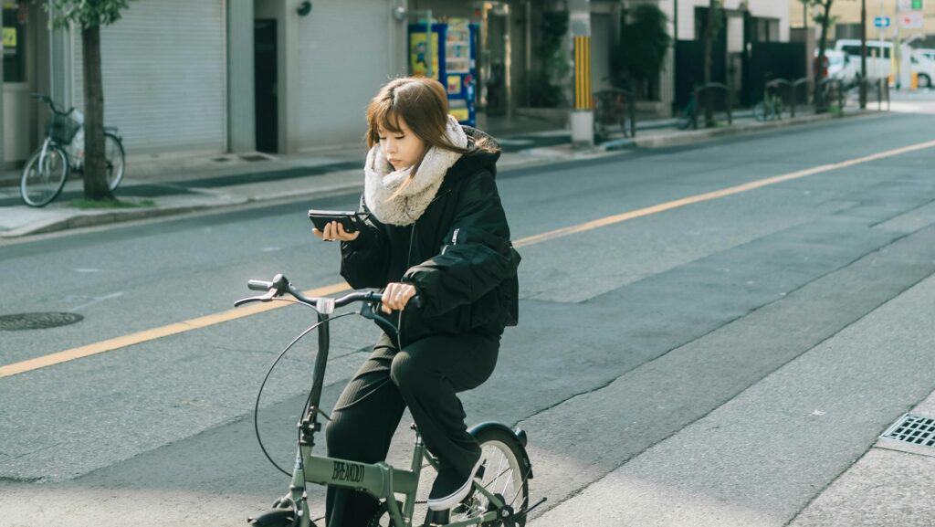Junge Frau auf dem Fahrrad konzentriert sich aufs Handy