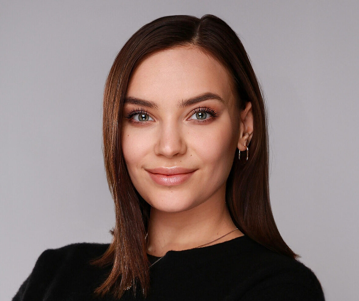 L&auml;chelnde Frau in schwarzem Pullover